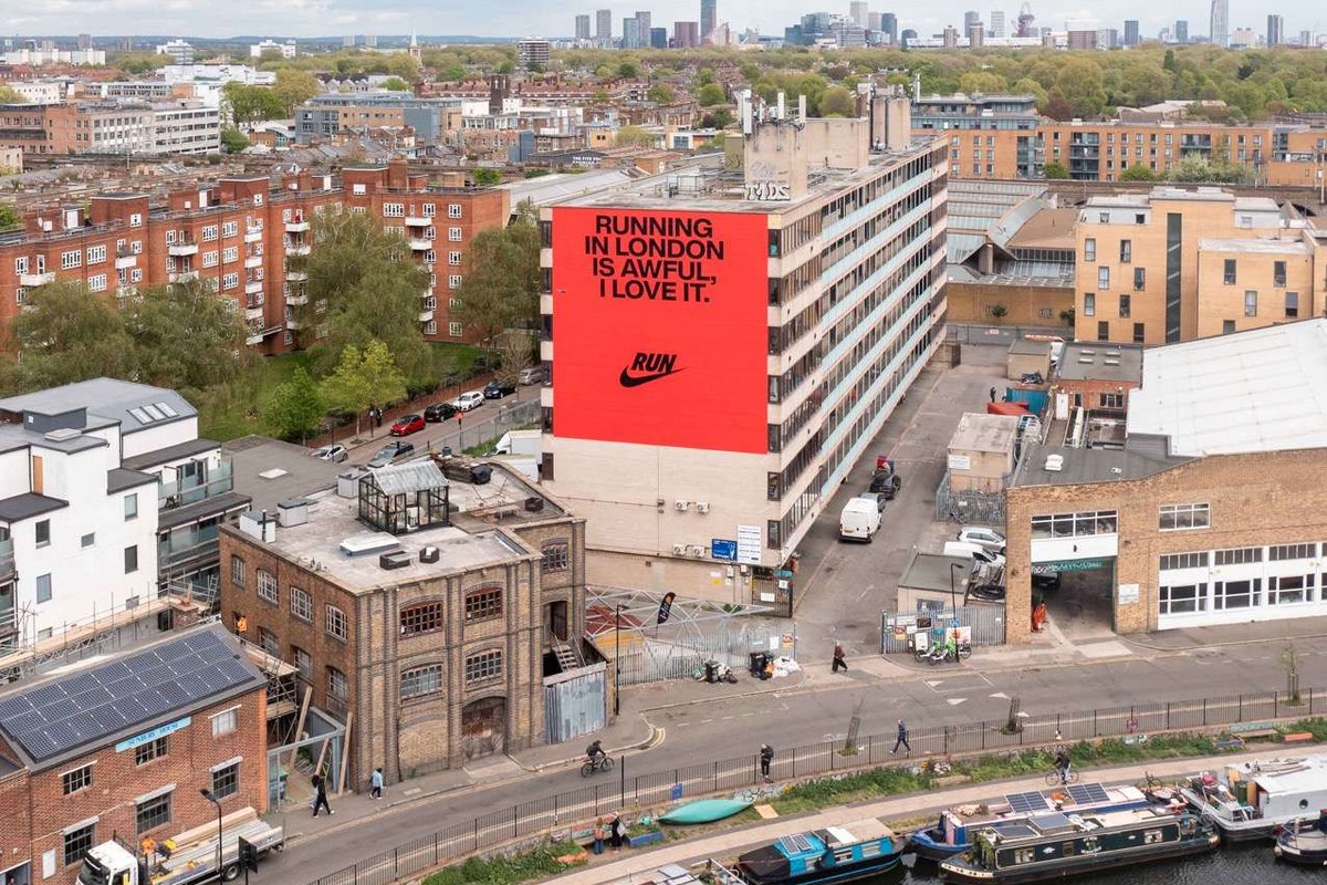 An aerial view of a city block with a large hand-painted advertisement filling one building end