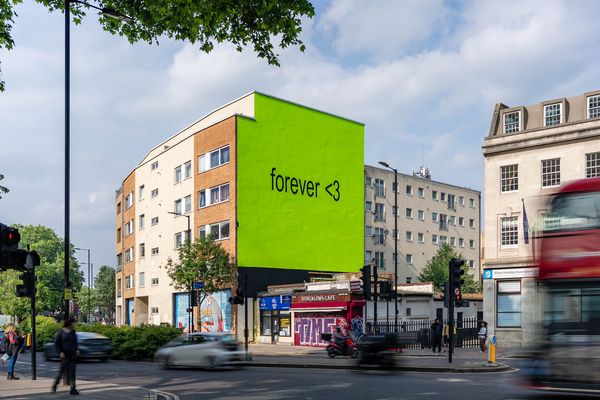 A building end painted a flat bright green with two words in small dark type