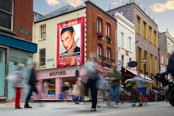 A building end painted with a portrait above a row of shopfronts