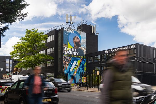 A building end painted with a runner and large lettering above an office block