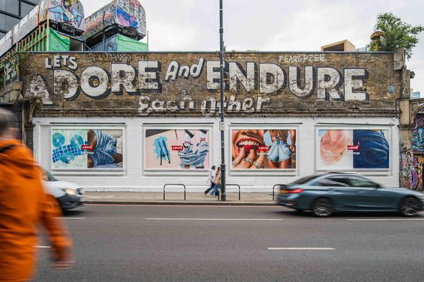 A long wall painted with large hand-lettered type above a row of painted panels