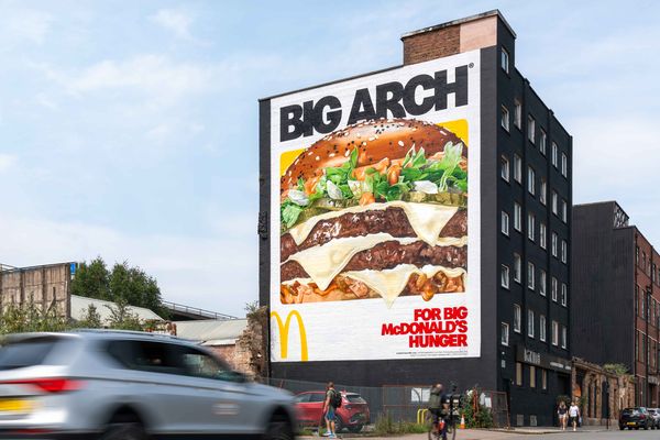 A tall building end painted with a burger and large display lettering