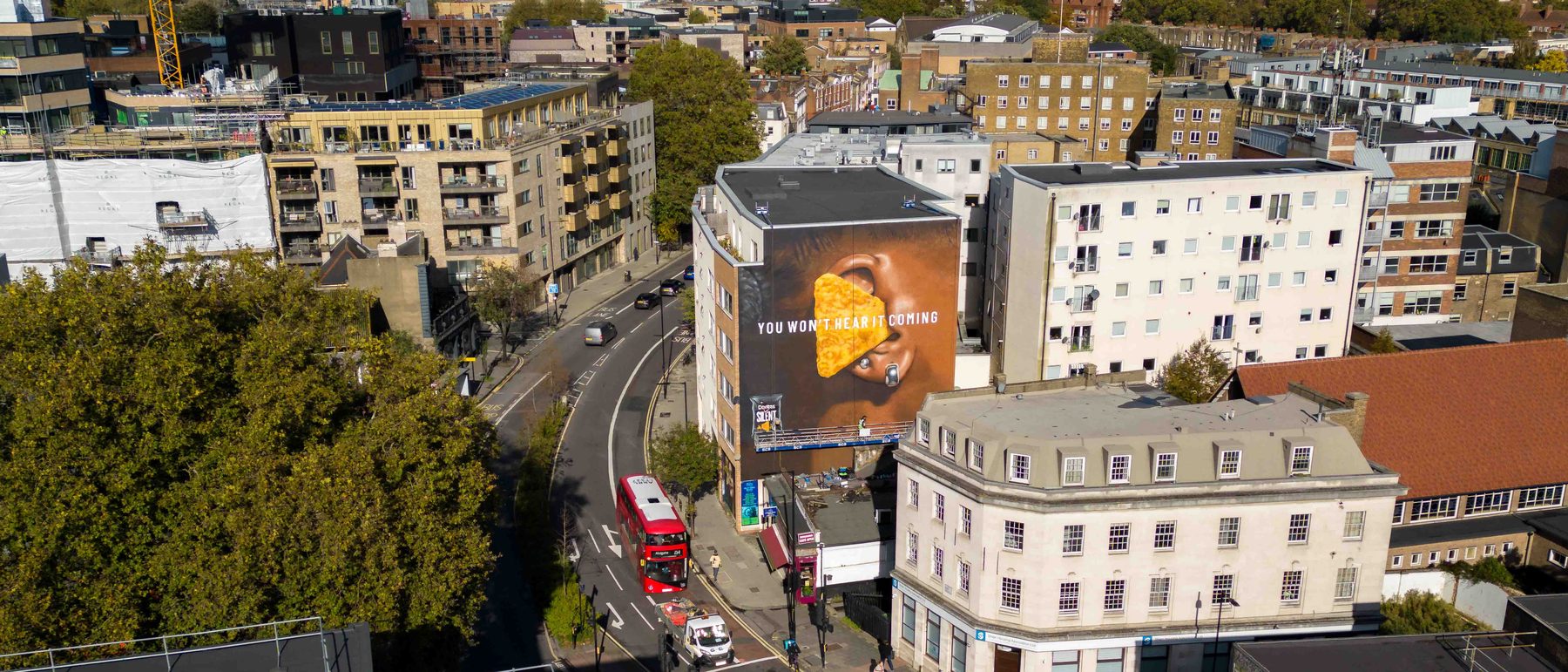An enormous hand-painted wall seen from the air above East London
