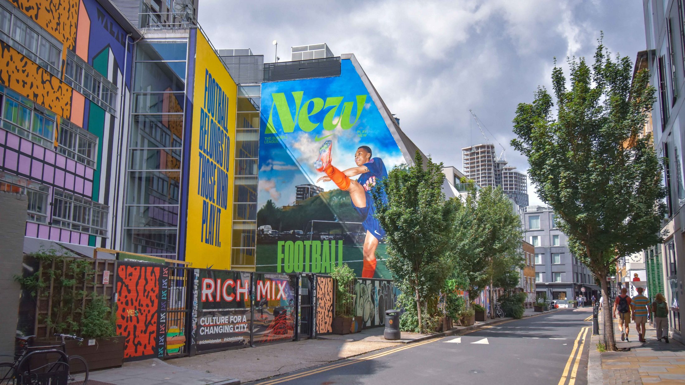 A full building-height hand-painted campaign on a Shoreditch street